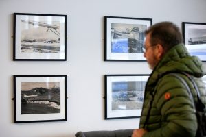 Flughafen von Iceland Air Fluggast schaut sich gerahmte alte Fotografien der Airline im Terminal an